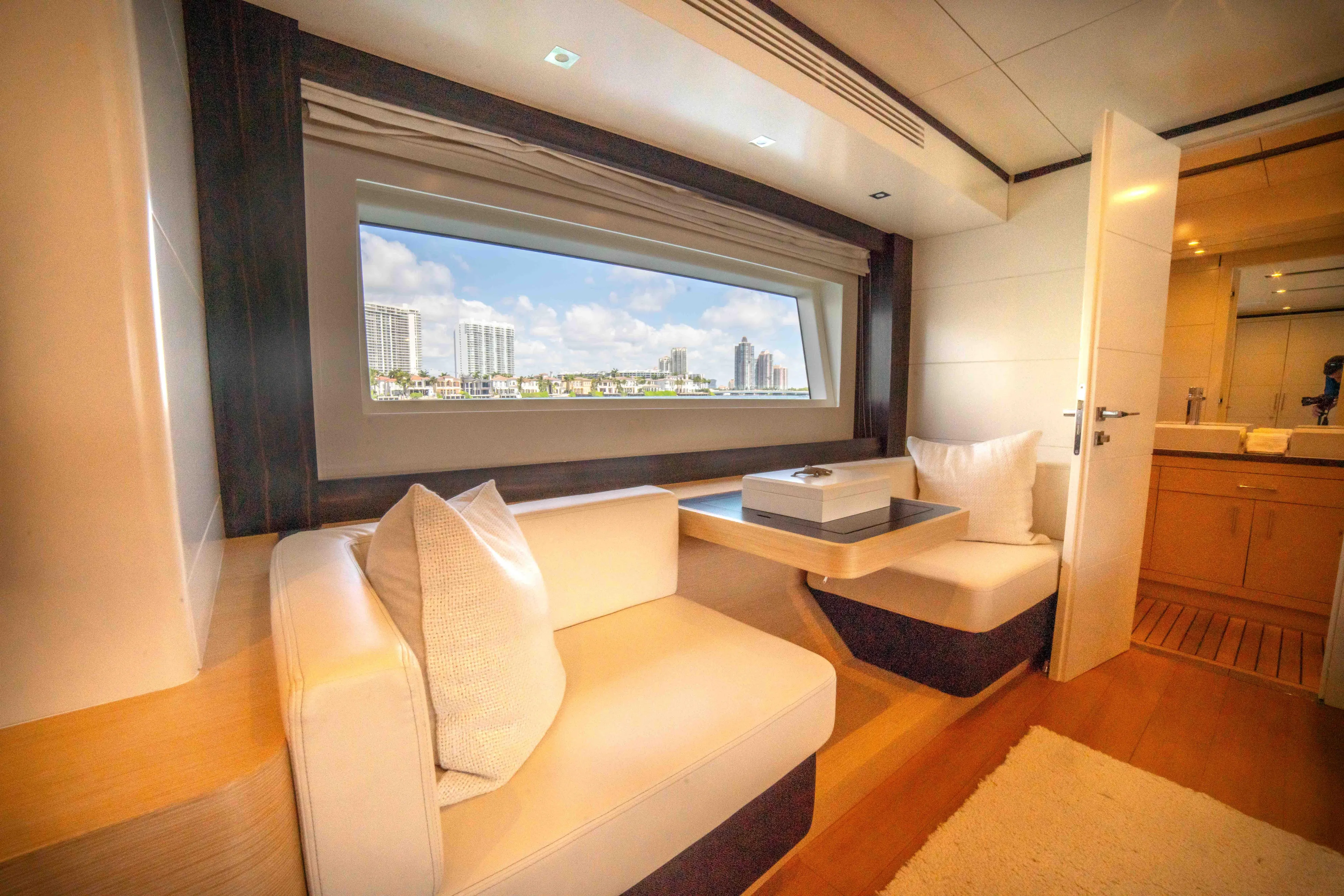 Sand Bar Yacht Photos Pics Luxurious interior of 2018 Sirena 64 yacht with cityscape view through window.