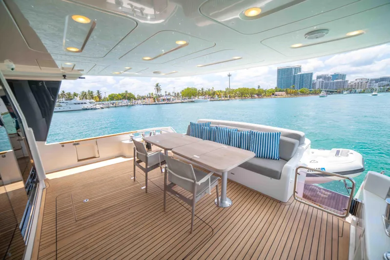 Sand Bar Yacht Photos Pics Outdoor deck of 2018 Sirena 64 yacht with dining area and waterfront view.