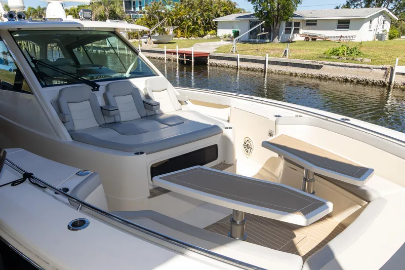  Yacht Photos Pics 2020 Scout 530LXF luxury boat interior with seating and tables, docked by a canal.