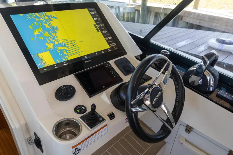  Yacht Photos Pics Control panel of a 2020 Scout 530LXF boat with navigation display and steering wheel.