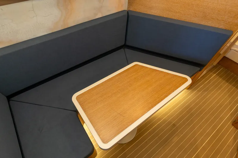  Yacht Photos Pics 2020 Scout 530LXF interior with wooden table and blue cushioned seating.