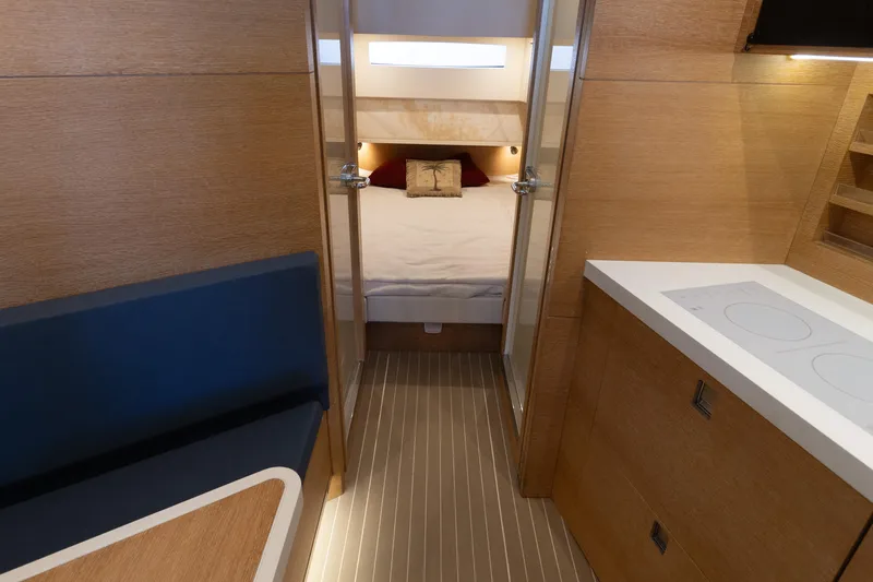  Yacht Photos Pics 2020 Scout 530LXF interior with modern wood finish, cozy bed, and compact kitchen area.