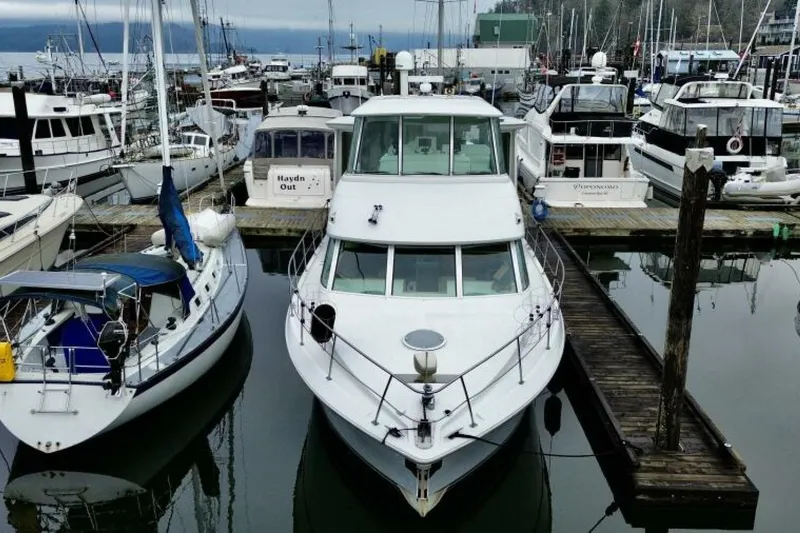 Family Affair IV Yacht Photos Pics 1997 Carver 500 Cockpit Motor Yacht docked at a marina, surrounded by other boats.