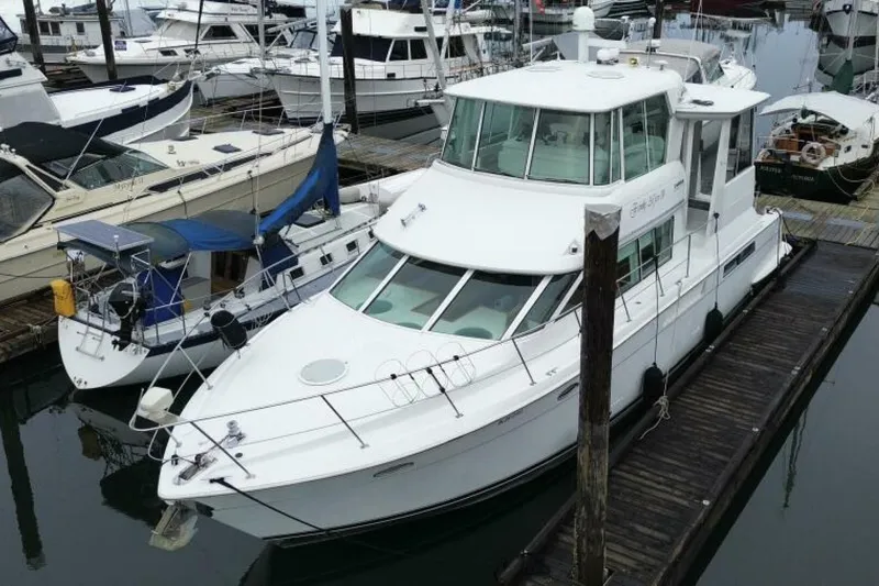 Family Affair IV Yacht Photos Pics 1997 Carver 500 Cockpit Motor Yacht docked at marina, surrounded by other boats.