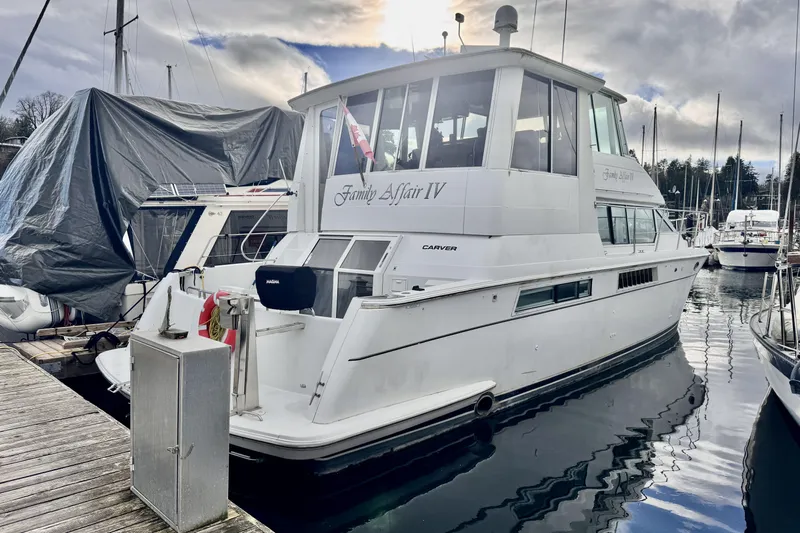 Family Affair IV Yacht Photos Pics 1997 Carver 500 Cockpit Motor Yacht docked at marina under cloudy sky.