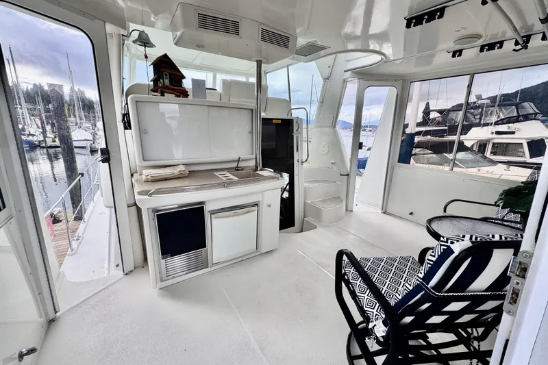 Family Affair IV Yacht Photos Pics 1997 Carver 500 Cockpit Motor Yacht interior with seating and kitchenette, docked at marina.