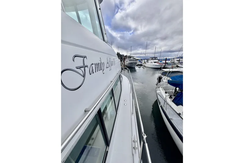 Family Affair IV Yacht Photos Pics 1997 Carver 500 Cockpit Motor Yacht docked in a marina, cloudy sky above.