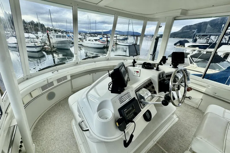 Family Affair IV Yacht Photos Pics Interior view of a 1997 Carver 500 Cockpit Motor Yacht helm with marina backdrop.