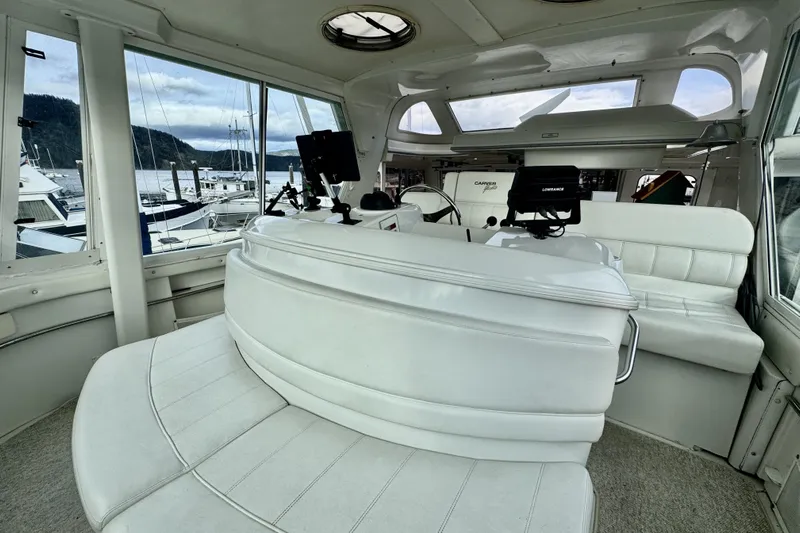 Family Affair IV Yacht Photos Pics Interior of a 1997 Carver 500 Cockpit Motor Yacht with white seating and navigation equipment.