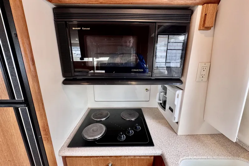 Family Affair IV Yacht Photos Pics Compact kitchen area in a 1997 Carver 500 Cockpit Motor Yacht with stove and microwave.