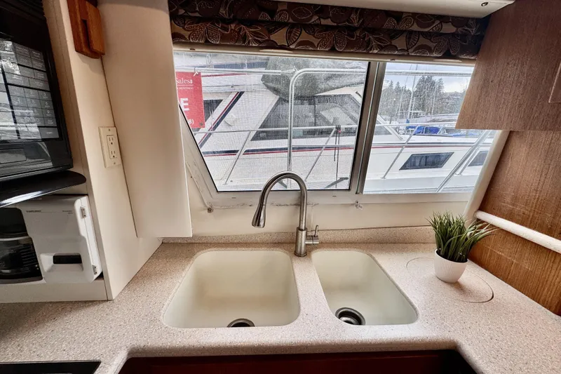 Family Affair IV Yacht Photos Pics Interior view of 1997 Carver 500 Cockpit Motor Yacht kitchen with dual sink and window.