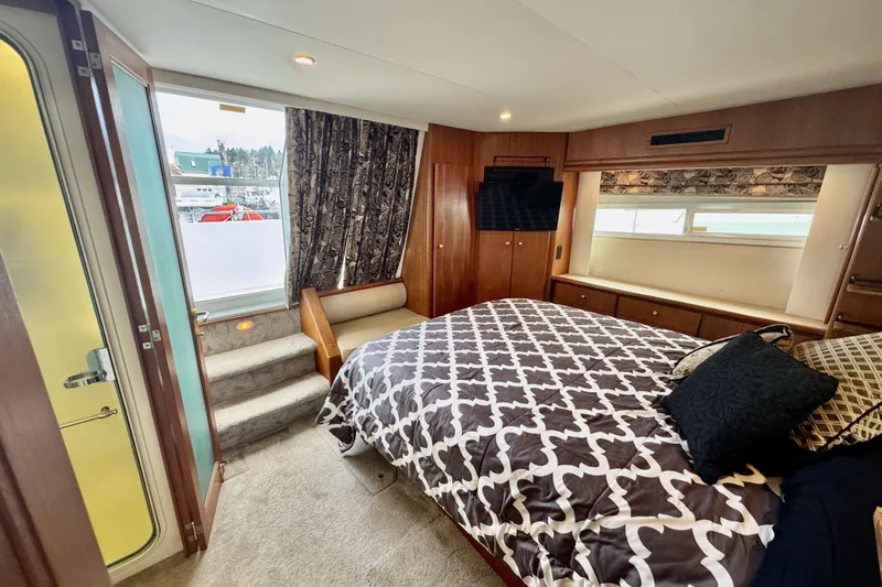 Family Affair IV Yacht Photos Pics Luxurious bedroom interior of 1997 Carver 500 Cockpit Motor Yacht with elegant bedding.