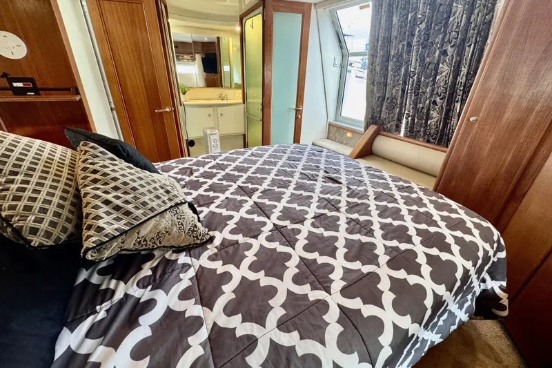 Family Affair IV Yacht Photos Pics Luxurious bedroom interior of 1997 Carver 500 Cockpit Motor Yacht with patterned bedding.