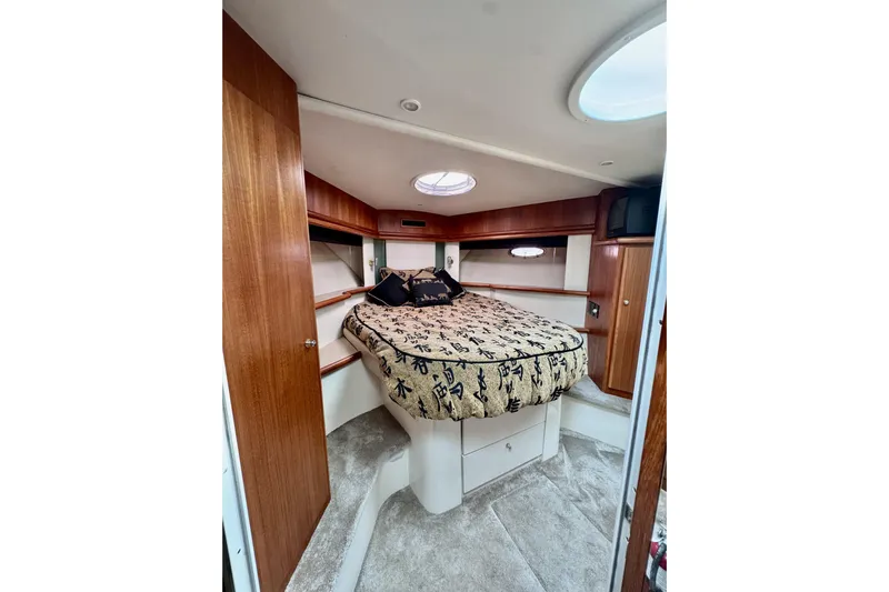Family Affair IV Yacht Photos Pics Interior of 1997 Carver 500 Cockpit Motor Yacht with cozy bed and wooden cabinetry.