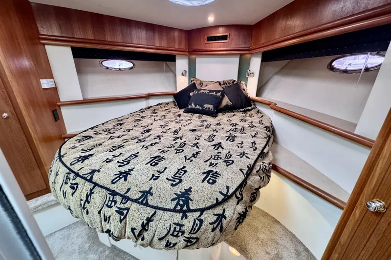 Family Affair IV Yacht Photos Pics Luxurious bedroom in 1997 Carver 500 Cockpit Motor Yacht with elegant bedding and wood accents.