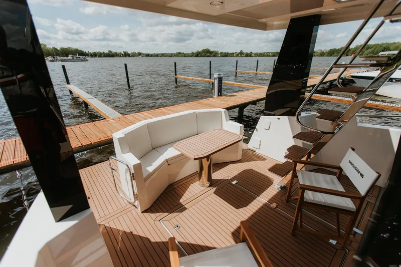  Yacht Photos Pics Luxurious 2026 Cobra Yachts Seamaster 45 deck with seating, table, and scenic water view.