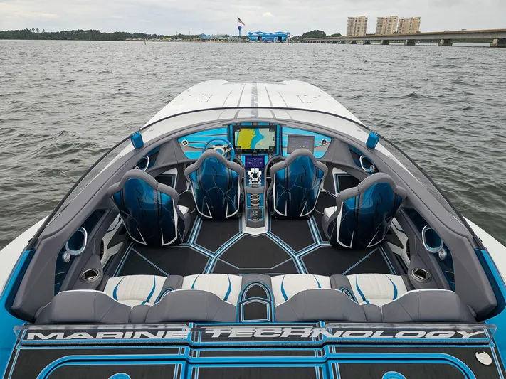  Yacht Photos Pics Luxury MTI 440X speedboat interior, 2026 model, featuring advanced navigation and stylish seating on open water.