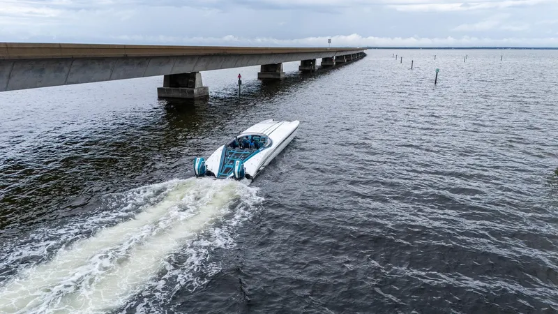  Yacht Photos Pics A 2026 MTI 440X powerboat cruising near a long bridge over open water.