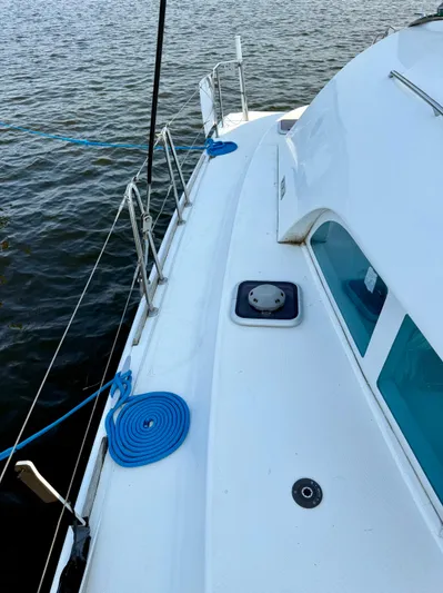 Wander Cat Yacht Photos Pics 2004 Lagoon 380 catamaran deck with blue ropes, docked by the water.