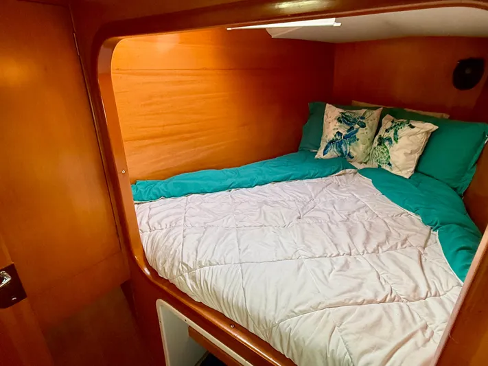 Wander Cat Yacht Photos Pics Cozy cabin bedroom in a 2004 Lagoon 380 catamaran with teal bedding and floral pillows.