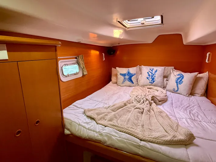Wander Cat Yacht Photos Pics Cozy cabin interior of 2004 Lagoon 380 catamaran with nautical-themed pillows and bedding.
