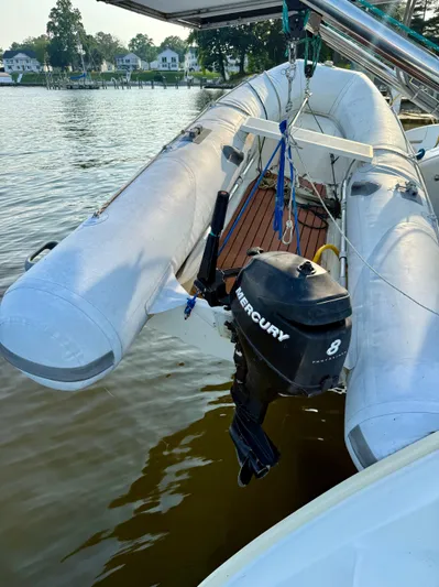 Wander Cat Yacht Photos Pics Inflatable boat with Mercury 8 outboard motor on Lagoon 380, 2004 model, docked by a lake.