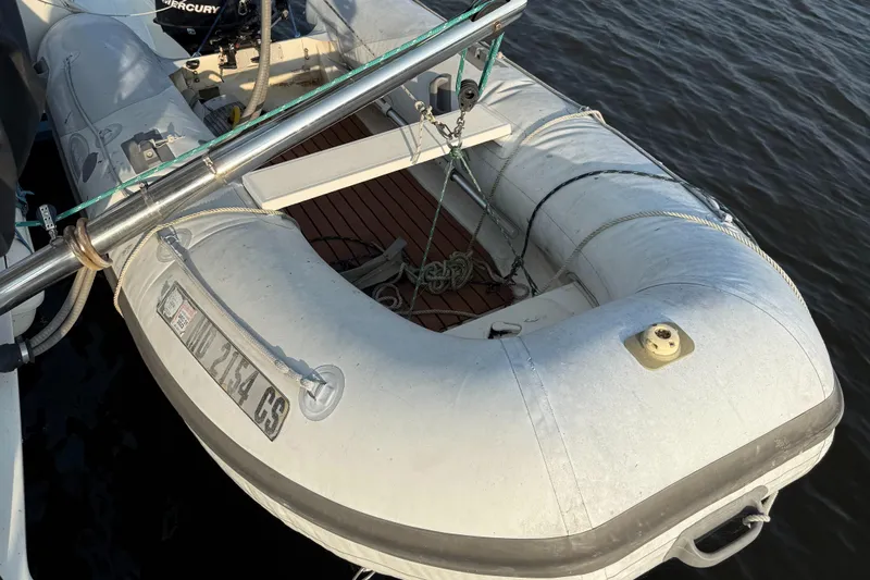 Wander Cat Yacht Photos Pics Inflatable dinghy attached to a 2004 Lagoon 380 catamaran, floating on calm water.