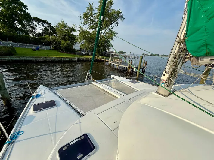 Wander Cat Yacht Photos Pics 2004 Lagoon 380 catamaran docked by a scenic waterfront with lush greenery.