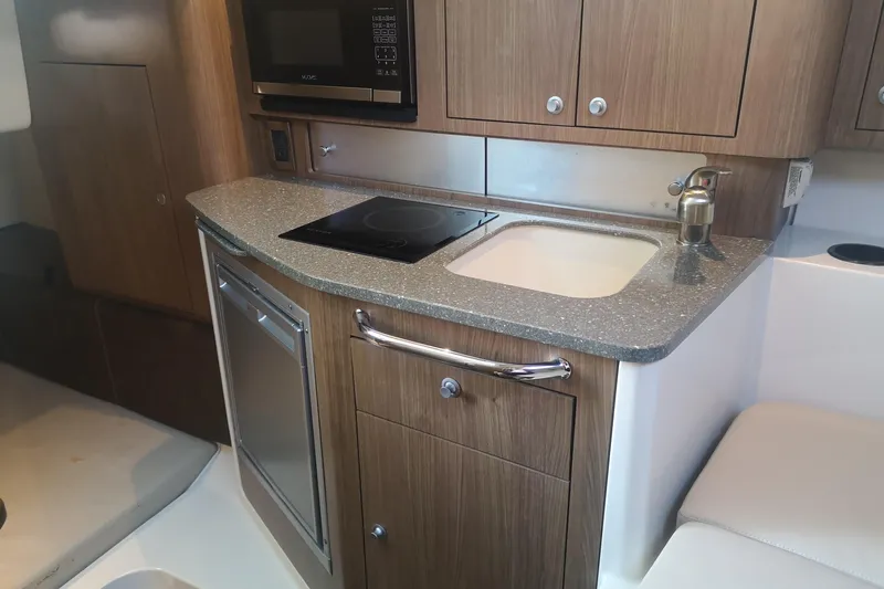  Yacht Photos Pics 2016 Boston Whaler 315 Conquest Pilothouse kitchen with sink, stove, and microwave.
