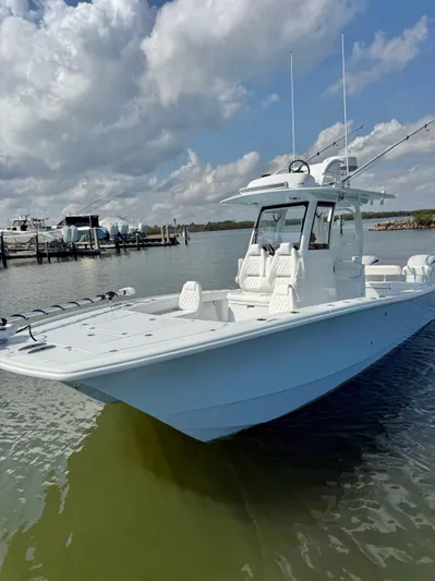 Yacht Photos Pics 2025 Freeman 28 boat docked on calm water under a cloudy sky.