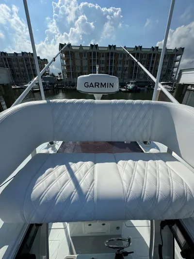  Yacht Photos Pics 2025 Freeman 28 boat with Garmin equipment, featuring white cushioned seating, docked near waterfront buildings.