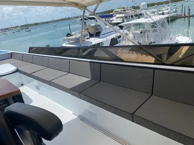 Audacity Yacht Photos Pics Luxury yacht deck with cushioned seating, overlooking marina. Broward Raised Pilothouse MY, 1990.