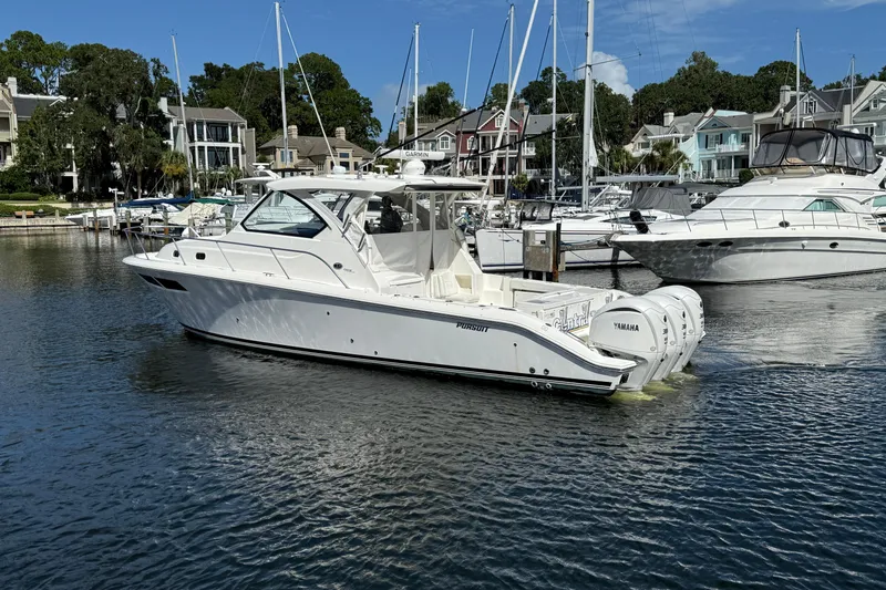 Centra Yacht Photos Pics 2023 Pursuit OS 355 Offshore boat docked in a marina with other yachts.