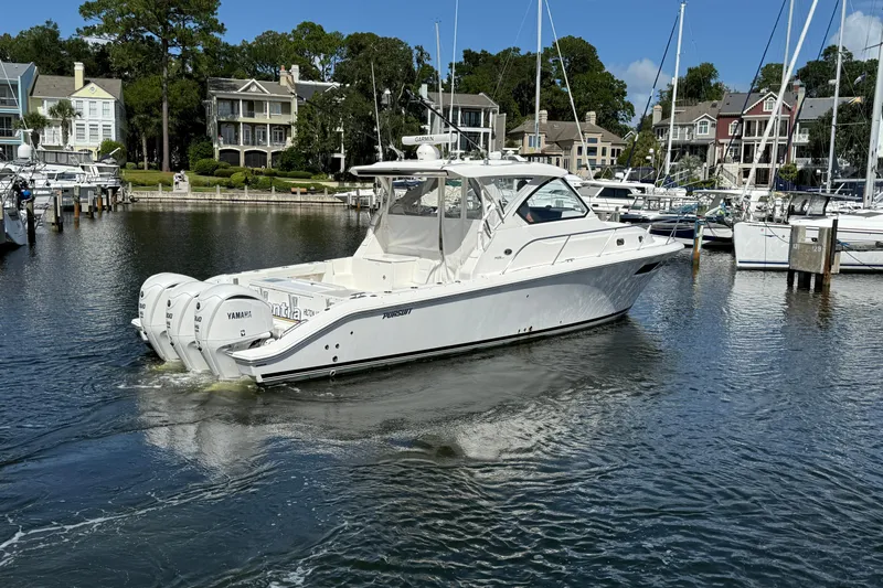 Centra Yacht Photos Pics 2023 Pursuit OS 355 Offshore boat in marina, surrounded by waterfront homes and yachts.