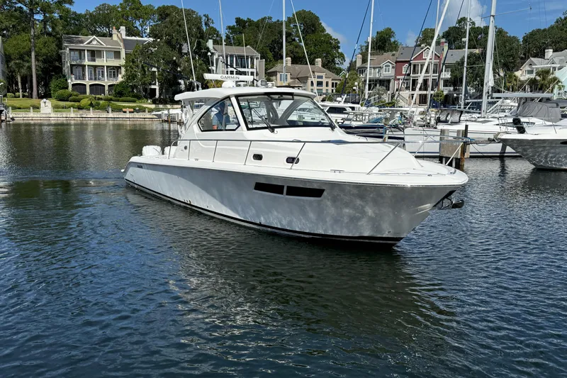 Centra Yacht Photos Pics 2023 Pursuit OS 355 Offshore boat docked in a scenic marina setting.