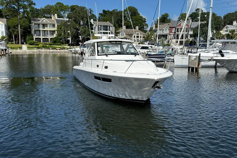 Centra Yacht Photos Pics 2023 Pursuit OS 355 Offshore boat docked in a scenic marina.