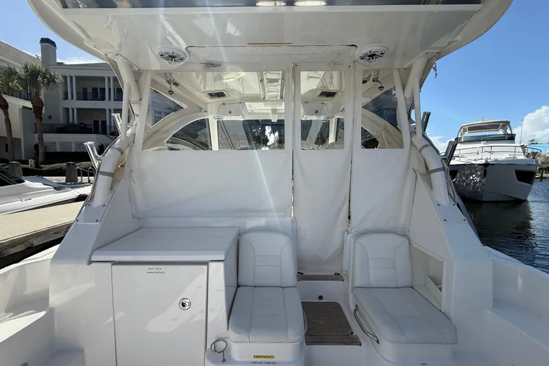 Centra Yacht Photos Pics 2023 Pursuit OS 355 Offshore boat interior with white seating and storage, docked at marina.