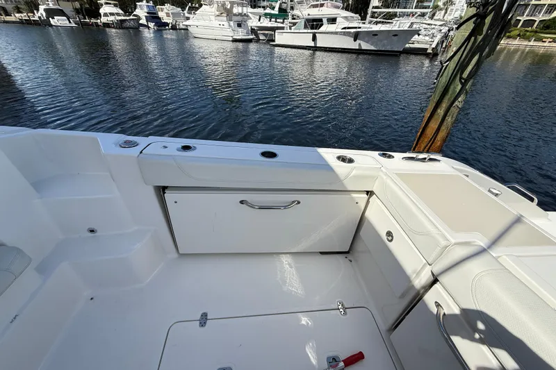 Centra Yacht Photos Pics 2023 Pursuit OS 355 Offshore boat interior with storage and seating, docked at marina.