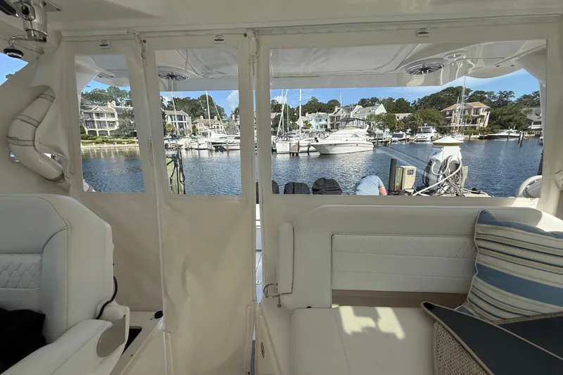 Centra Yacht Photos Pics 2023 Pursuit OS 355 Offshore interior view, overlooking marina with boats and waterfront homes.