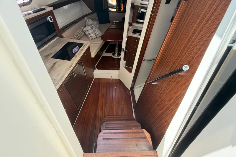 Centra Yacht Photos Pics 2023 Pursuit OS 355 Offshore cabin interior with wood finish and modern amenities.