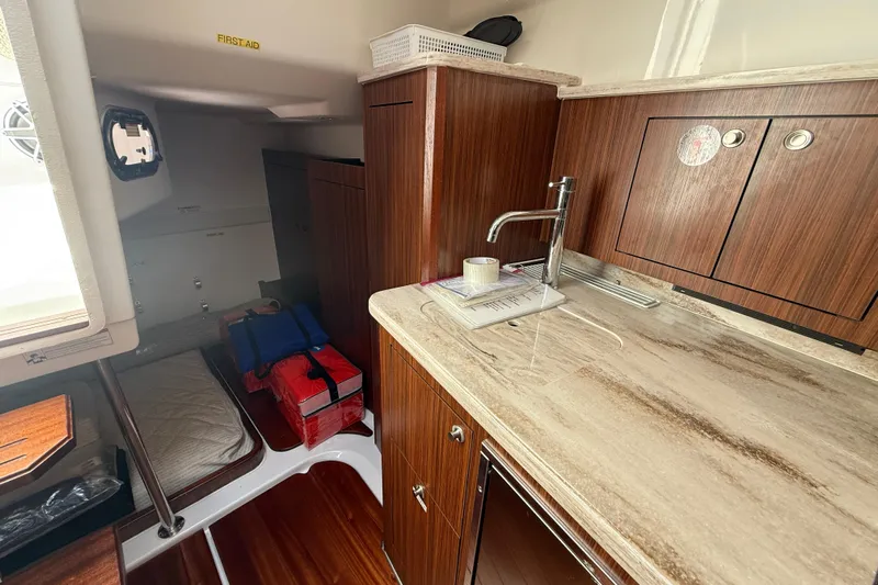 Centra Yacht Photos Pics 2023 Pursuit OS 355 Offshore cabin interior with kitchenette and sleeping area.
