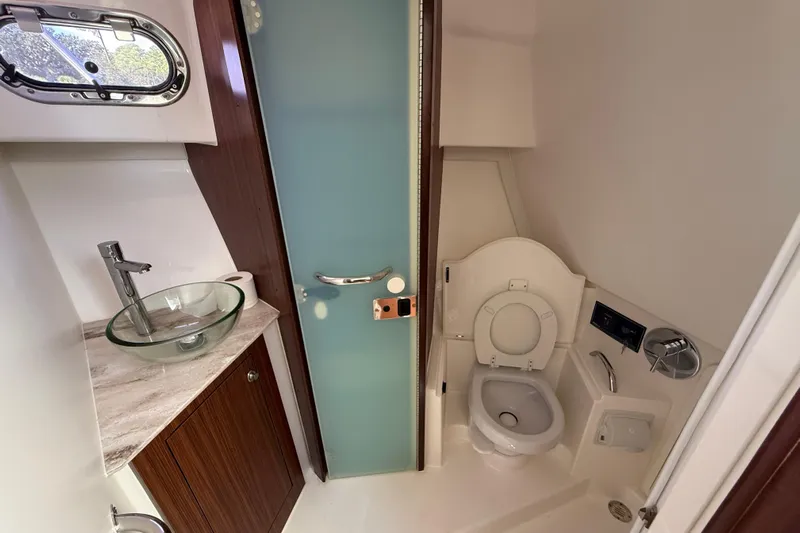 Centra Yacht Photos Pics 2023 Pursuit OS 355 Offshore boat bathroom with glass sink and modern fixtures.