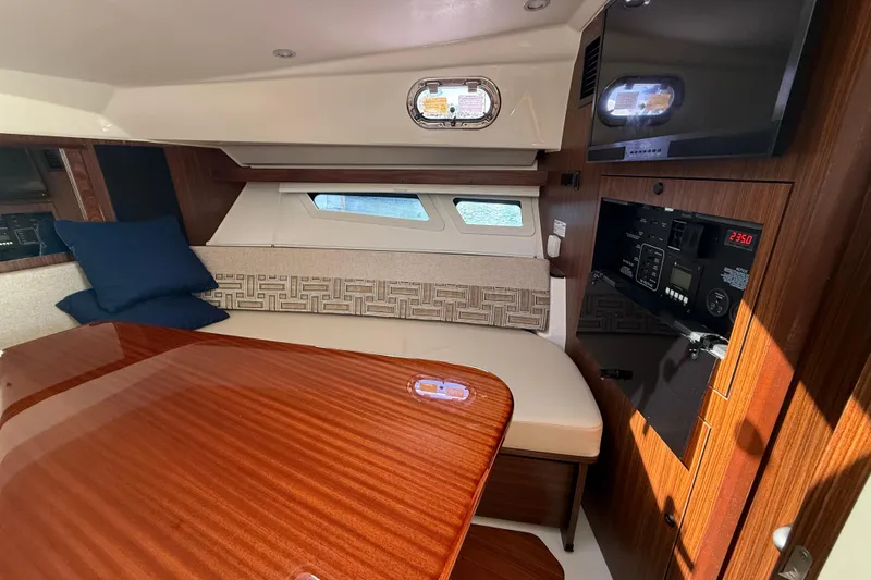 Centra Yacht Photos Pics Luxurious interior of 2023 Pursuit OS 355 Offshore boat with wood finish and seating area.