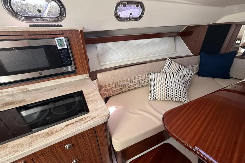 Centra Yacht Photos Pics 2023 Pursuit OS 355 Offshore interior with kitchen and cozy seating area.