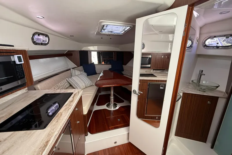 Centra Yacht Photos Pics 2023 Pursuit OS 355 Offshore cabin interior with modern kitchen and seating area.