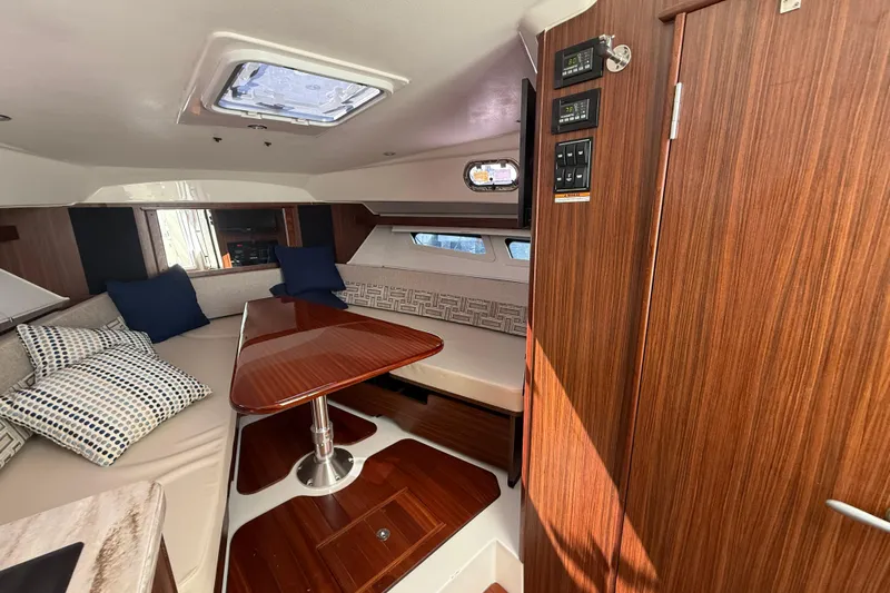 Centra Yacht Photos Pics 2023 Pursuit OS 355 Offshore cabin interior with wood finish and seating area.