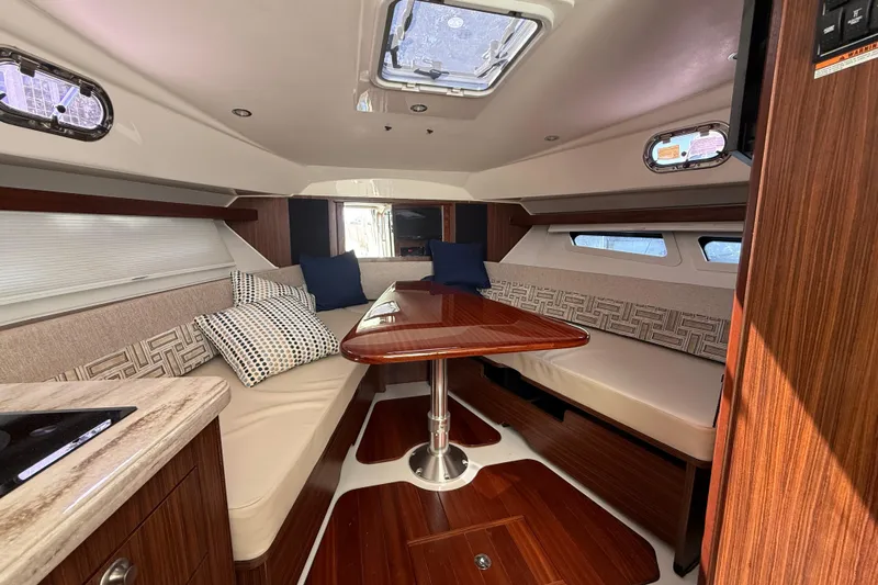 Centra Yacht Photos Pics 2023 Pursuit OS 355 Offshore cabin interior with elegant seating and wooden finishes.