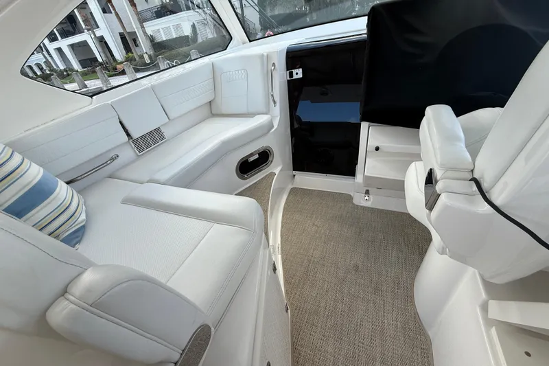 Centra Yacht Photos Pics Luxurious interior of 2023 Pursuit OS 355 Offshore boat with white seating and striped pillow.