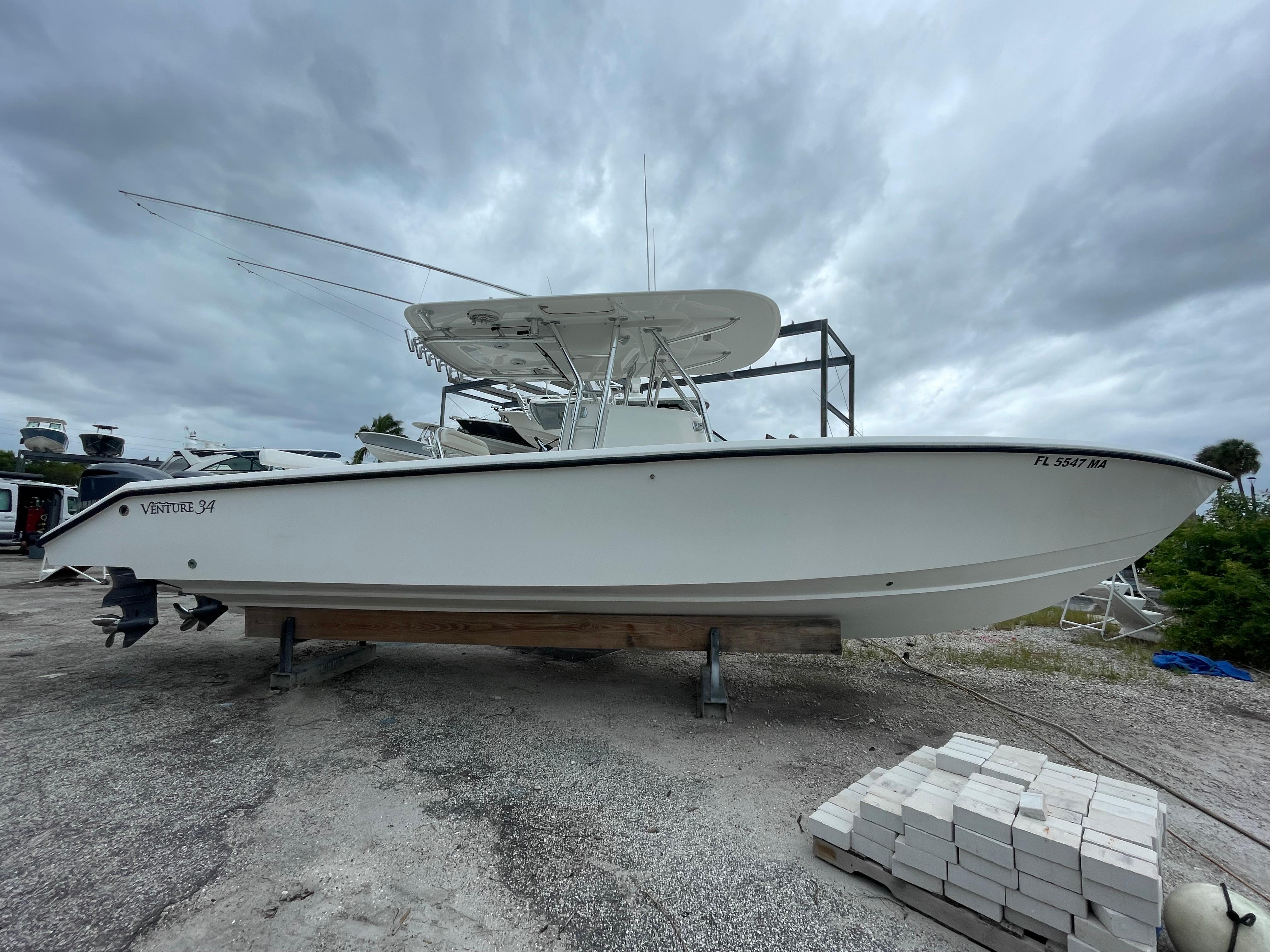 2000 Venture 34 Tournament boat on dry dock under cloudy sky.