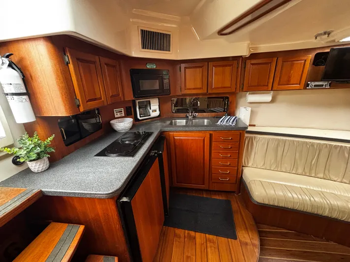 Martuni Yacht Photos Pics 2002 Luhrs 40 Open yacht interior with kitchen, wooden cabinets, and seating area.